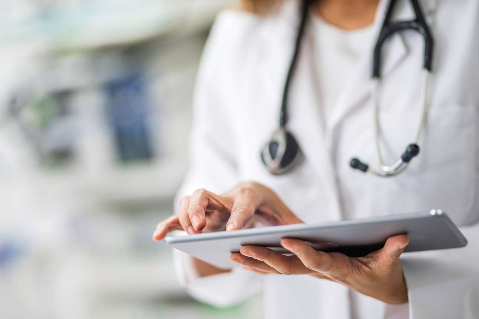 Person in white coat with stethoscope on a tablet.